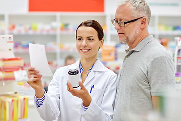 Image showing pharmacist and senior man buying drug at pharmacy