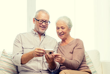 Image showing happy senior couple with camera at home