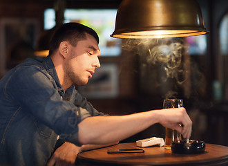 Image showing man drinking beer and smoking cigarette at bar