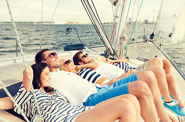 Image showing smiling friends lying on yacht deck