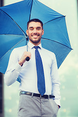 Image showing young smiling businessman with umbrella outdoors