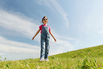 Image showing happy little girl over green field and blue sky