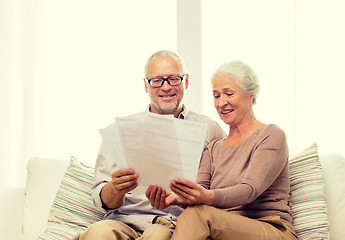 Image showing happy senior couple with papers at home