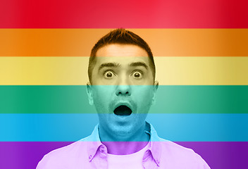 Image showing shocked gay man shouting over rainbow flag