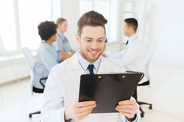 Image showing happy doctor with tablet pc over team at clinic