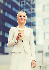 Image showing smiling businesswoman with paper cup outdoors