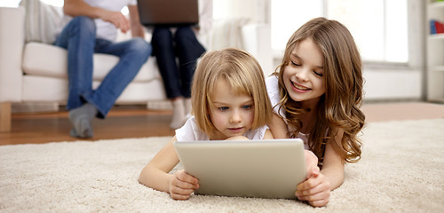 Image showing happy little girls with tablet pc computer at home