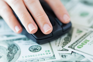 Image showing close up of hand with computer mouse on money