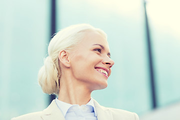 Image showing young smiling businesswoman over office building