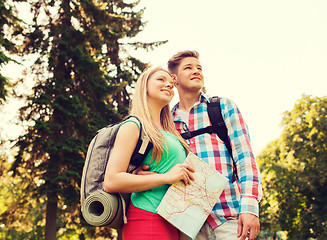 Image showing smiling couple with map and backpack in nature