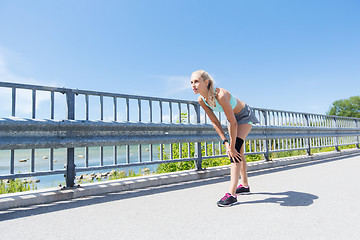 Image showing young woman with injured knee or leg outdoors