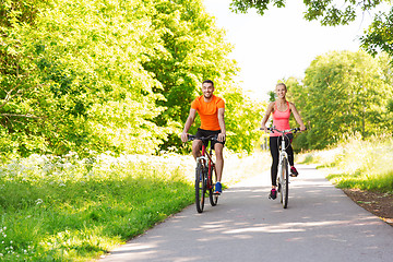 Image showing happy couple riding bicycle outdoors