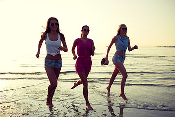 Image showing group of smiling women running on beach