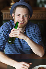 Image showing happy young man drinking beer at bar or pub