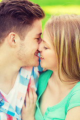 Image showing smiling couple kissing and hugging in park