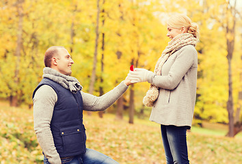 Image showing smiling couple with engagement ring in gift box