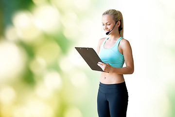 Image showing happy woman trainer with microphone and clipboard