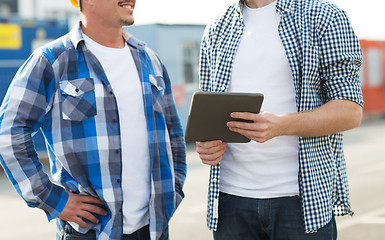 Image showing close up of builders with tablet pc outdoors