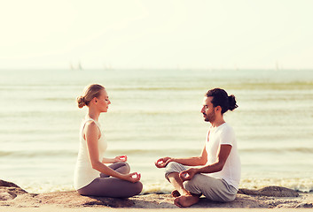 Image showing smiling couple making yoga exercises outdoors