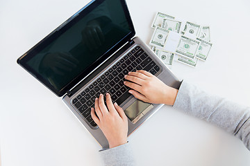 Image showing close up of woman hands with laptop and money