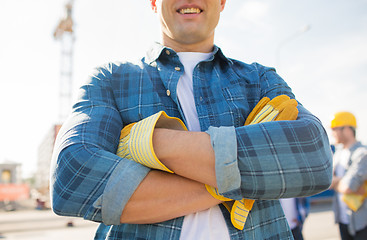 Image showing close up of smiling builder hands in gloves