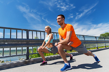 Image showing smiling couple stretching outdoors