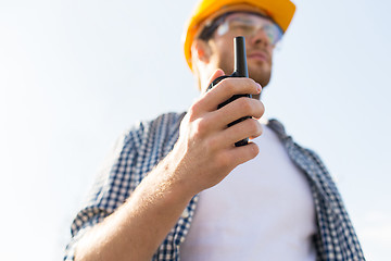 Image showing close up of builder in hardhat with walkie talkie