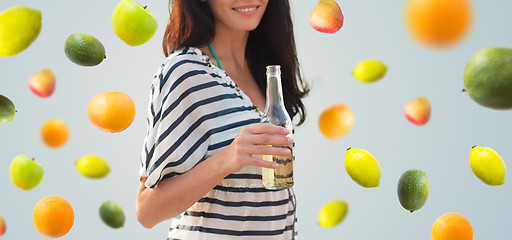 Image showing close up of smiling young woman drinking on beach