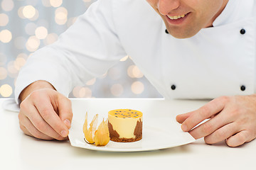 Image showing close up of happy male chef cook with dessert