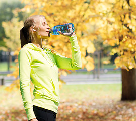 Image showing woman drinking water after doing sports outdoors