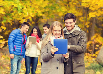 Image showing group of smiling friends with tablets in park