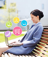 Image showing smiling business woman with laptop in city