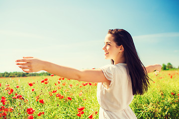 Image showing smiling young woman on poppy field