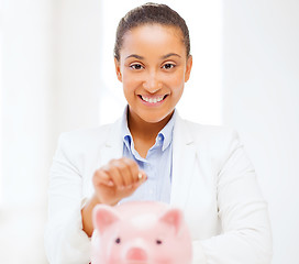 Image showing woman with piggy bank and coin