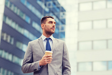 Image showing young serious businessman with paper cup outdoors