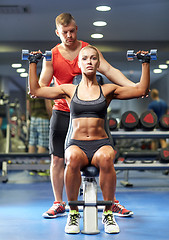 Image showing man and woman with dumbbells in gym