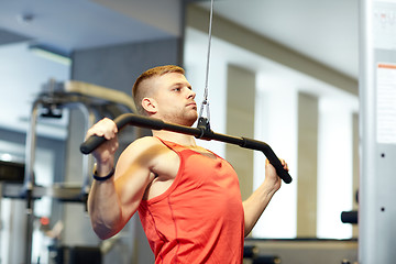 Image showing man flexing muscles on cable machine gym