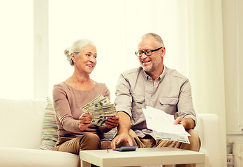 Image showing senior couple with money and calculator at home