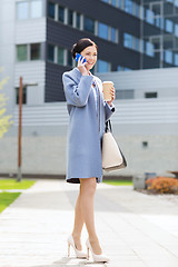 Image showing happy businesswoman calling on smartphone in city 