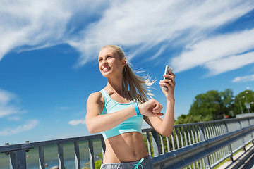 Image showing happy woman with heart rate watch and smartphone