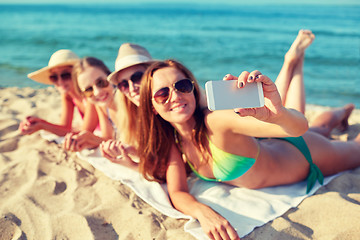 Image showing close up of smiling women with smartphone on beach