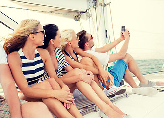 Image showing smiling friends sitting on yacht deck