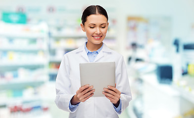 Image showing smiling female doctor with tablet pc at drugstore