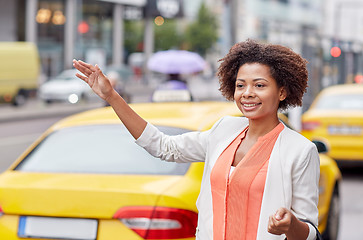 Image showing happy african woman catching taxi