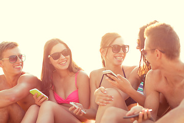 Image showing friends with smartphones on beach