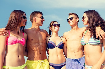 Image showing smiling friends in sunglasses on summer beach