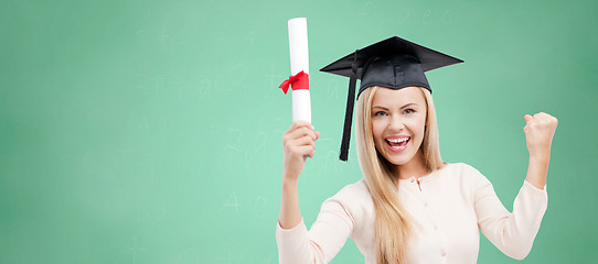 Image showing student in trencher cap with diploma over green