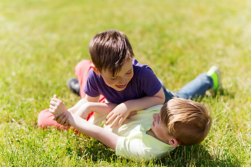 Image showing happy little boys fighting for fun on grass