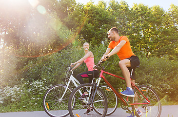 Image showing happy couple riding bicycle outdoors