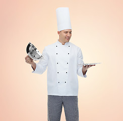 Image showing happy male chef cook opening cloche